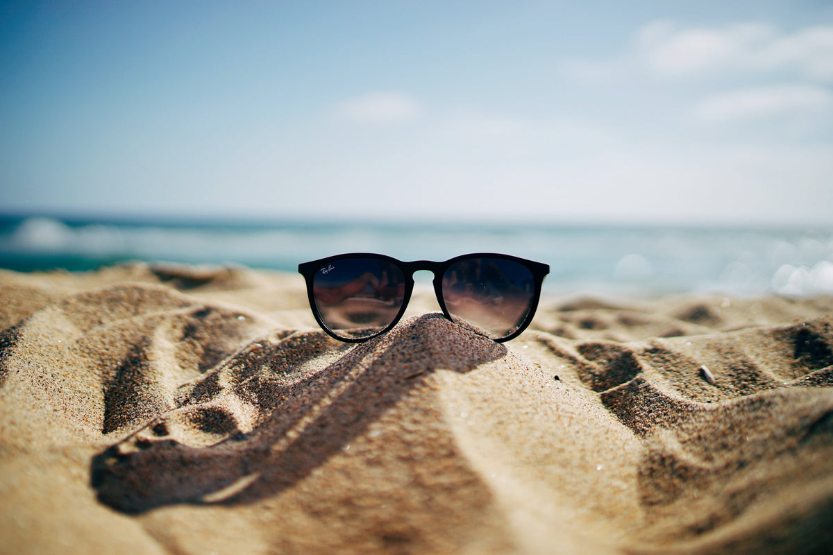Gafas de sol negras sobre la arena de una playa