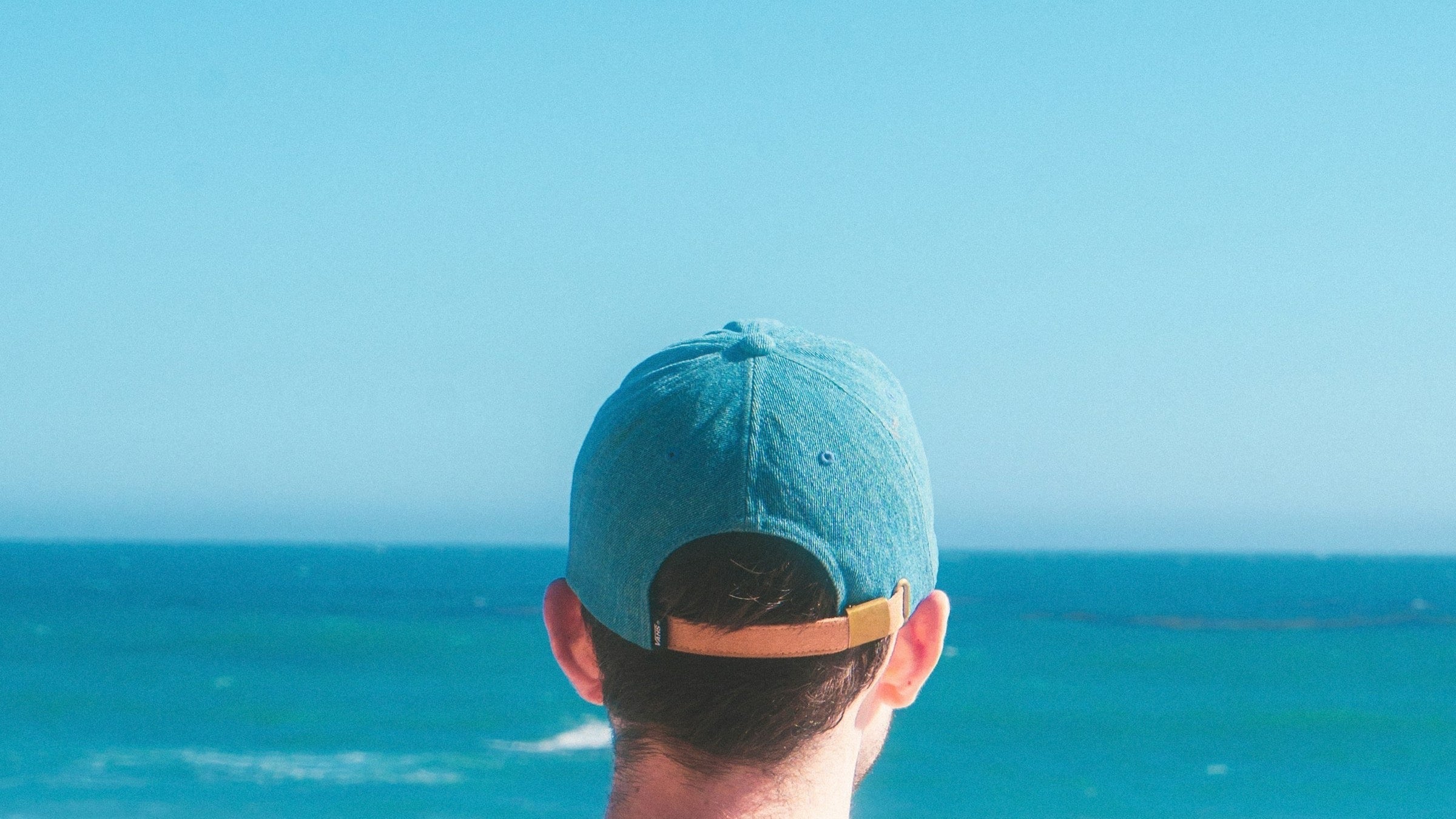 Gorra real frente al mar, portada horizontal de guía de gorras surferas