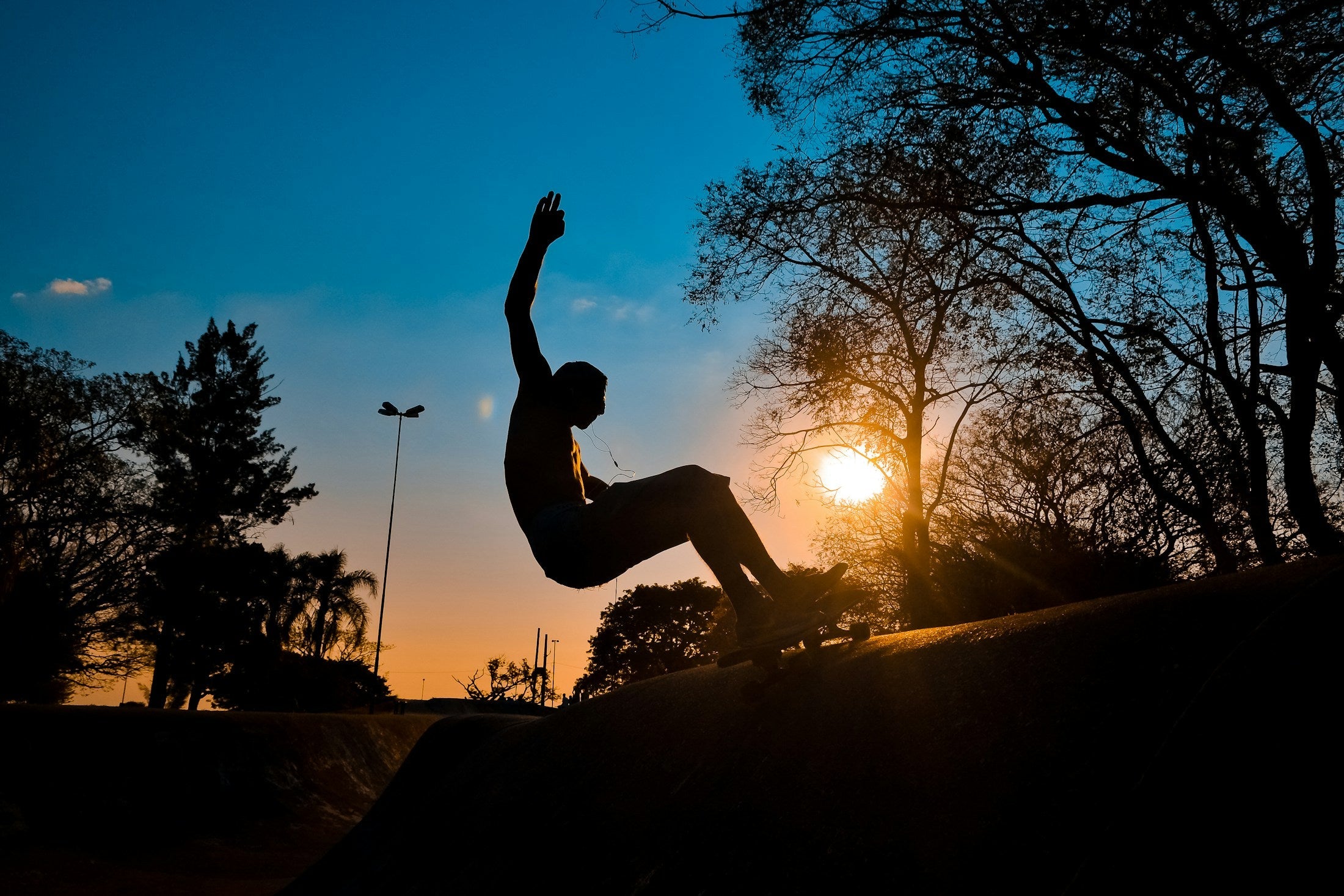 Skater en silueta realizando una maniobra al atardecer, portada real del artículo de entrenamiento con surfskate