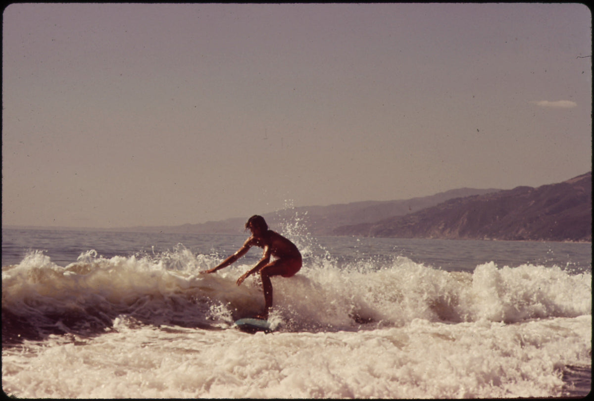 Surfista con longboard en una ola de Malibu en 1972