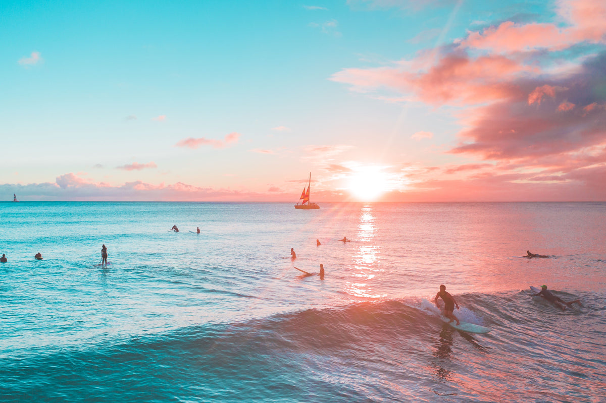 Surfistas en el mar al atardecer durante una sesión de surf