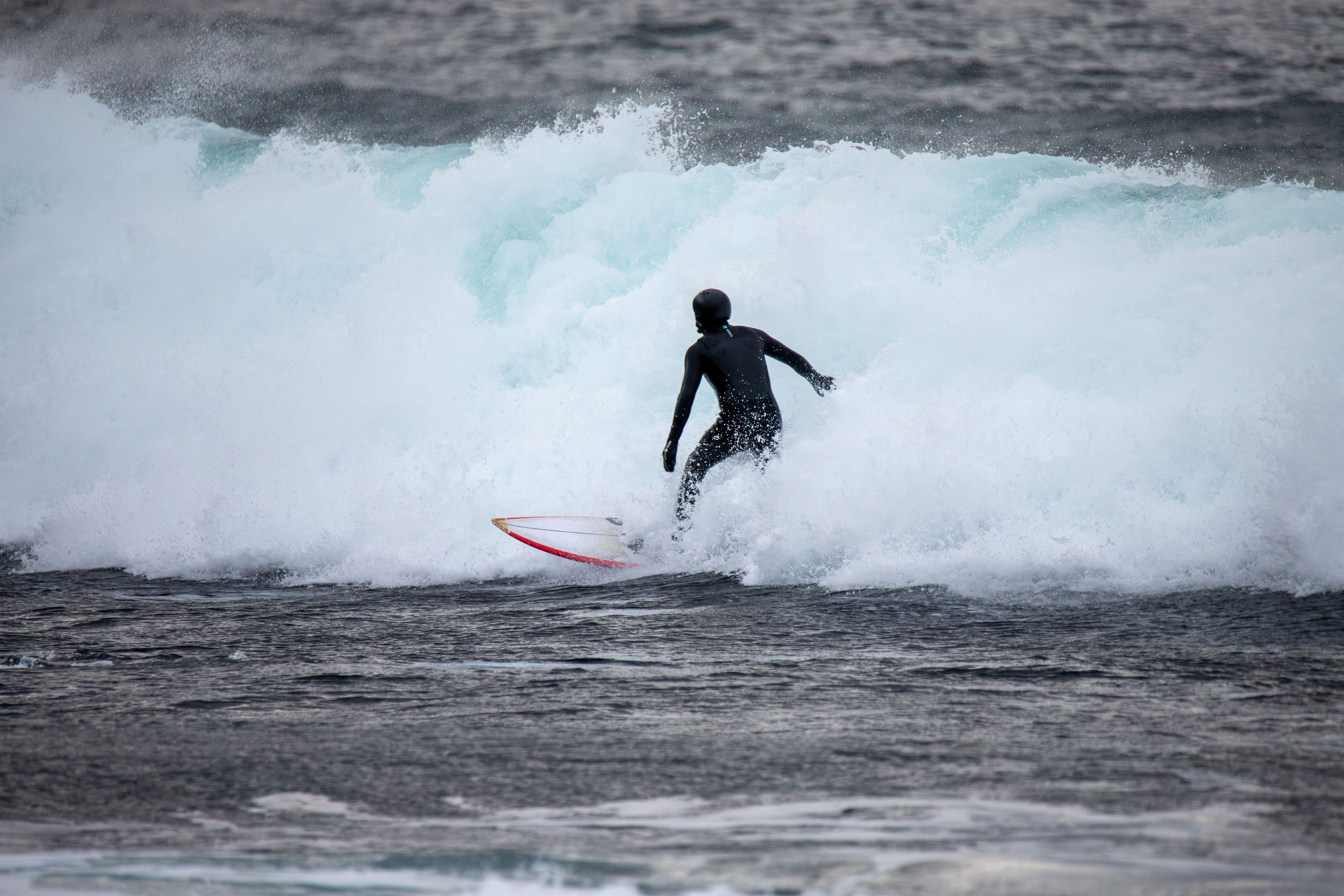 Surfista con neopreno en olas frías de invierno en Noruega
