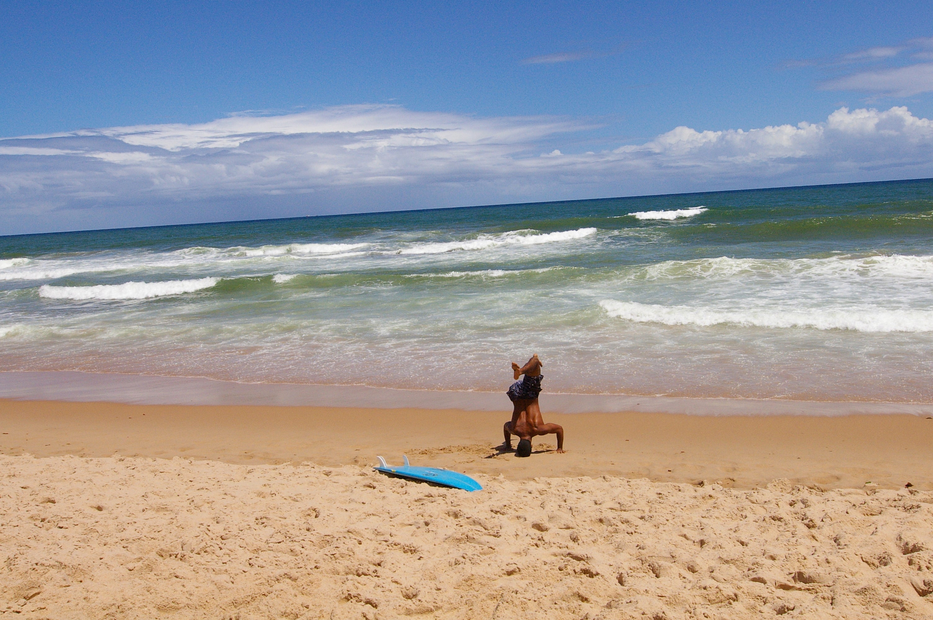 Surfista realizando un calentamiento dinámico en una playa de Bahía antes de entrar al agua