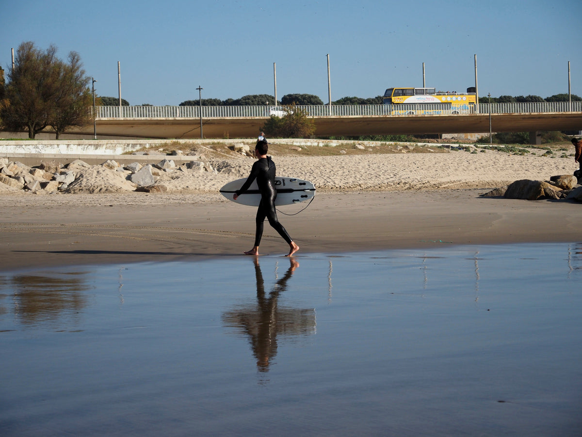 Surfista en la playa de Matosinhos después de una sesión, contexto para cambiarse con un poncho de surf