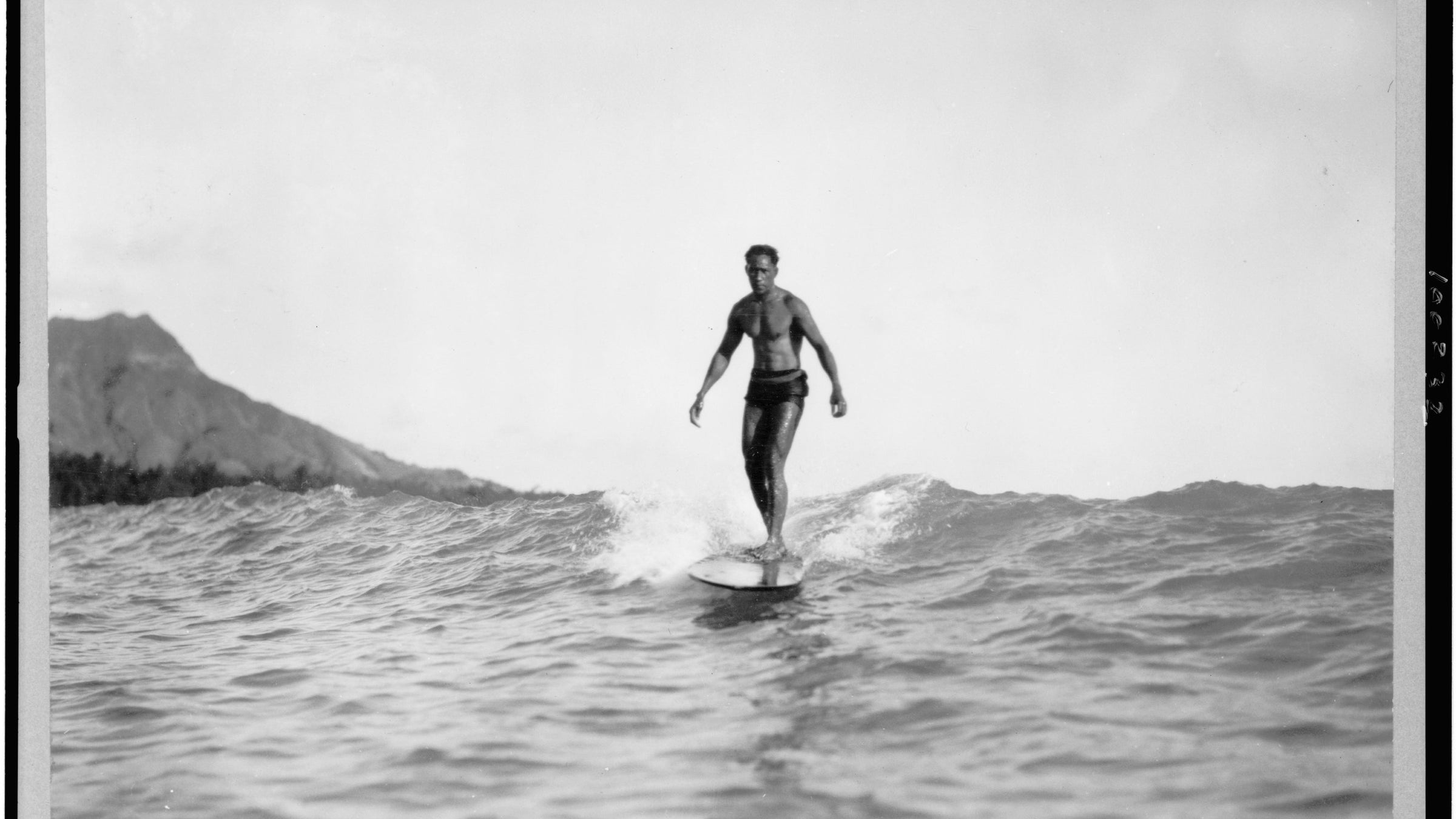 Surfista en una ola de Honolulu en 1929, contexto histórico de las innovaciones de Tom Blake