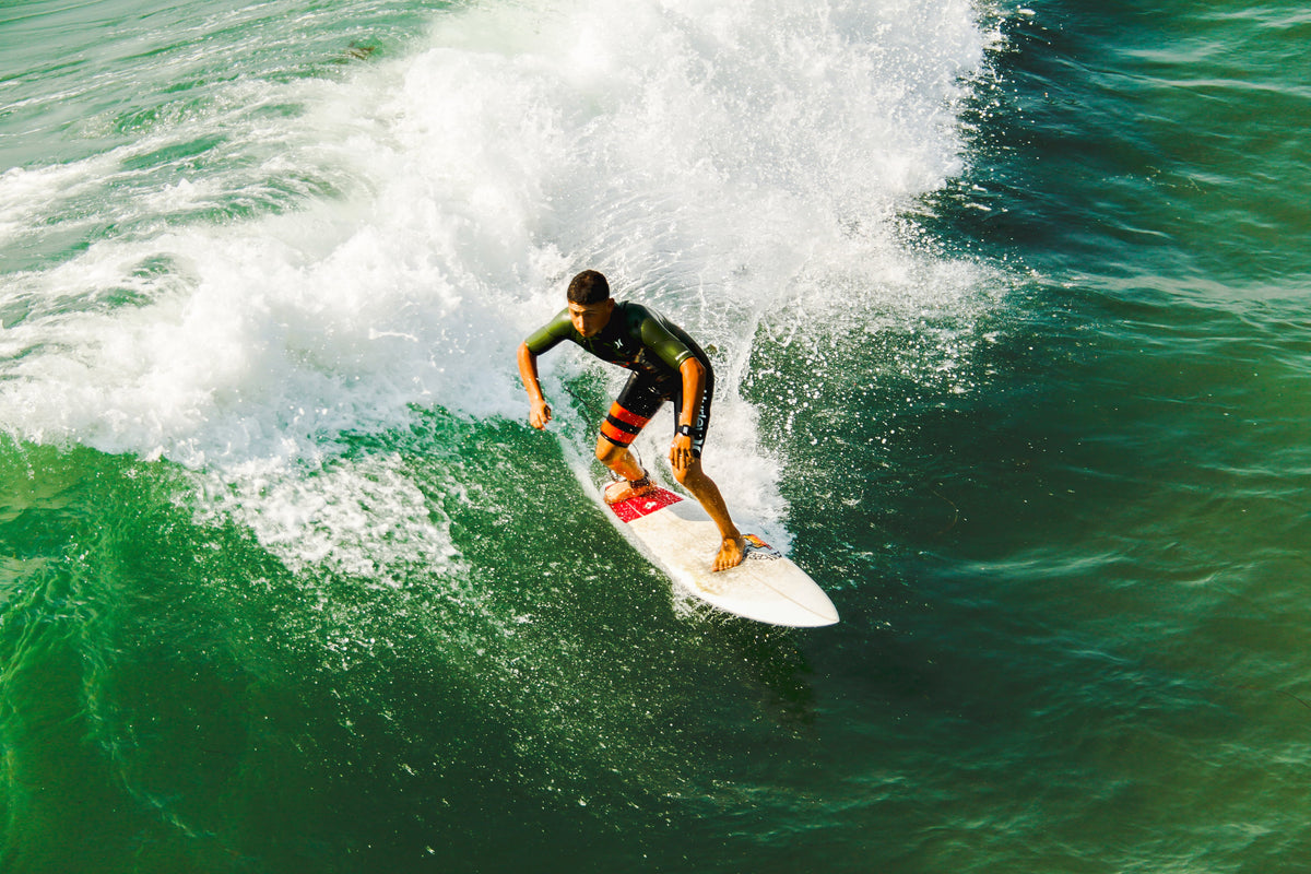 Surfista con traje de surf en una ola de Imperial Beach, imagen real para THE SURF TOWN JOURNAL