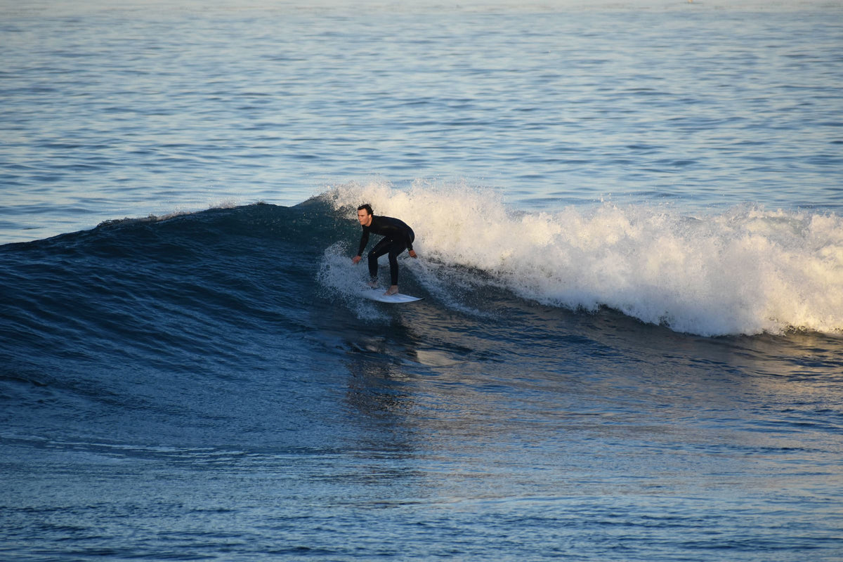 Surfista entrando en una pared con viento de tierra