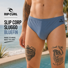 Bañador de natación Rip Curl Slip Corp Sluggo Bluefin en campaña lifestyle surf premium junto a piscina y costa tropical
