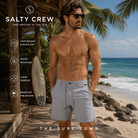 Bermudas Salty Crew Transom Tech Short Quarry frente a palmeras del mar Caribe, fotografía editorial propia de THE SURF TOWN con modelo masculino surf lifestyle, bermuda técnica ligera color gris Quarry para verano