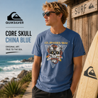 Camiseta Quiksilver Core Skull China Blue hombre en diseño surfwear premium con gráfico skull retro y estética coastal vintage