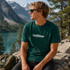 Camiseta Quiksilver Fineline Trekking Green hombre en campaña outdoor lifestyle premium junto a lago de montaña y naturaleza salvaje