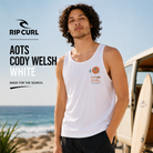 Camiseta tirantes Rip Curl Aots Cody Welsh White hombre en campaña surf lifestyle premium junto a furgoneta surfer y playa soleada
