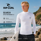 Licra Rip Curl Search UPF50 Performance White LS para hombre en fotografía editorial propia de THE SURF TOWN junto al mar con protección solar UPF 50+, manga larga y tejido técnico para surf y deportes acuáticos.