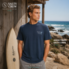 Camiseta Salty Crew AFrame Crossover Navy para hombre en escenario surf lifestyle premium junto al mar