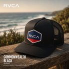 Gorra Rvca Commonwealth Black en campaña surf lifestyle premium junto al océano y madera coastal vintage