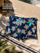 Bañador de natación Rip Curl Corp Boyleg Sluggo Printed Navy Blue sobre toalla de playa en escena surf cinema aesthetic premium