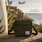 Bandolera Herschel Classic Crossbody Ivy Green en fotografía editorial propia de THE SURF TOWN con escenario coastal premium y estilo surf travel lifestyle