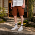 Bermudas Billabong Hibrido Crossfire Solid 20 Rustic Brown para hombre en jardín japonés minimalista con fotografía editorial propia de THE SURF TOWN, estilo surf lifestyle premium y ambiente relajado de viaje
