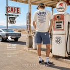 Fotografía propia de THE SURF TOWN de las bermudas Carhartt WIP Flint Short Dusky Blue Garment Dyed para hombre en una gasolinera vintage de Route 66 con estética roadtrip americana y ambiente lifestyle premium.