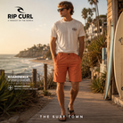 Bermudas híbridas Rip Curl Boardwalk Terracota para hombre en paseo costero surf junto al océano, fotografía editorial propia de THE SURF TOWN inspirada en el surf lifestyle premium