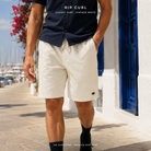 Bermudas Rip Curl Classic Surf 19 Volley Vintage White para hombre en un puerto mediterráneo, imagen editorial propia de THE SURF TOWN.
