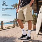 Bermudas Volcom Strage Tripper 22 Khaki en paseo marítimo surf lifestyle frente al mar, fotografía editorial propia de THE SURF TOWN con estilo masculino casual y ambiente costero premium