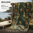 Toalla de playa Billabong Waves Moss Green, fotografía editorial propia de THE SURF TOWN en un entorno costero junto a una tabla de surf, inspirada en un auténtico surf trip y el estilo de vida beach lifestyle.
