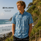 Camisa Billabong Surftrek Perf Indigo Blue en fotografía editorial propia de THE SURF TOWN junto a olas y sendero costero en surf trip premium