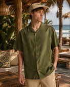 Camisa Billabong Vacay Linen verde para hombre en beach club tropical junto al mar