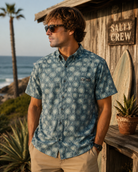 Camisa hombre Salty Crew Drifter UV Button Up Magnet azul estampada en entorno surf shack premium junto al mar estilo Costa del Sol