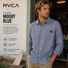 Camisa RVCA Day Shift Moody Blue para hombre en taller industrial con estilo surf workwear premium