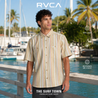 Hombre con camisa RVCA Talum Ceramic de rayas en un puerto tropical, imagen editorial propia de THE SURF TOWN