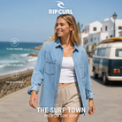Camisa vaquera Rip Curl Pacific Rider Blue para mujer en una escena vacacional junto al océano, imagen editorial propia de THE SURF TOWN