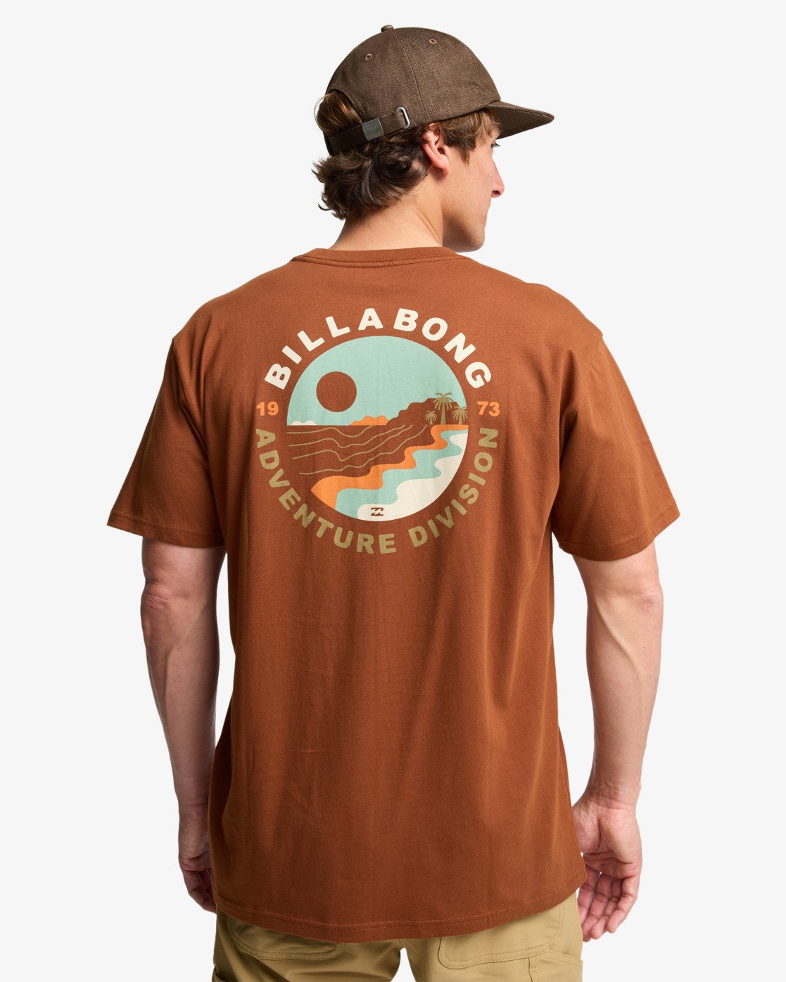 Camiseta Billabong Rockies Rust para hombre en color rust marrón teja con pequeño logo en el pecho y gran ilustración trasera estilo surf y aventura.