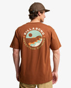 Camiseta Billabong Rockies Rust para hombre en color rust marrón teja con pequeño logo en el pecho y gran ilustración trasera estilo surf y aventura.
