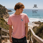 Camiseta Billabong Troppo Ash Rose en fotografía editorial propia de THE SURF TOWN sobre escaleras de madera hacia una playa salvaje con auténtico surf lifestyle premium