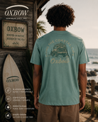 Camiseta Oxbow Weekender Cactus verde hombre con gráfica trasera en escenario coastal roadtrip premium y estética editorial surf cinematográfica
