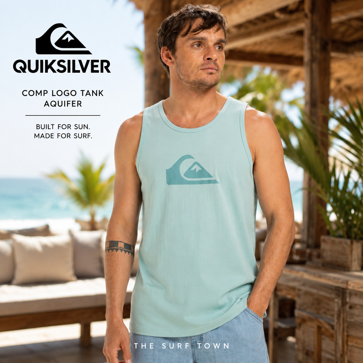 Camiseta Quiksilver Comp Logo Tank Aquifer para hombre en beach club tropical de Bali, fotografía editorial propia de THE SURF TOWN, camiseta de tirantes azul Aquifer con logo frontal Quiksilver.

Título del blog: