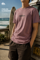 Camiseta Quiksilver Fineline Elderberry hombre en escena surf lifestyle premium junto a furgoneta y playa
