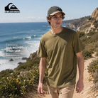 Camiseta Quiksilver Slub Roundneck Grape Leaf para hombre en fotografía editorial propia de THE SURF TOWN caminando por sendero costero junto al mar con luz solar natural, estilo surf lifestyle premium y entorno mediterráneo.