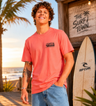 Camiseta Rip Curl rosa hombre estilo surf lifestyle premium junto a surf shack en la playa