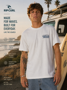 Camiseta Rip Curl Sportline FB White para hombre en escena surf lifestyle cinema aesthetic junto a furgoneta surf al atardecer