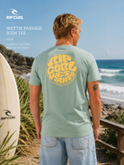 Camiseta Rip Curl Wettie Passage Icon Tee Aloe en escena surf lifestyle junto al océano con luz natural brillante