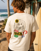 Camiseta RVCA Vacation Tag blanca estilo surf lifestyle en escena coastal premium junto al mar