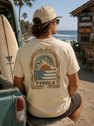 Camiseta Vissla Canopy Cosmic Wash Dune en ambiente retro surf lifestyle junto al mar