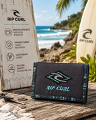 artera Rip Curl Archive Black Blue en escenario surf lifestyle premium con estética coastal adventure luminosa