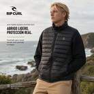 Chaleco Rip Curl Anti Series Search Puffer Vest Black para hombre en acantilado costero con ambiente outdoor premium