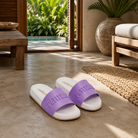 Fotografía propia de THE SURF TOWN de las chanclas de pala Petite Jolie Slide Lilac para mujer en el interior de un hotel de lujo en Bali con materiales naturales, luz tropical y ambiente resort lifestyle premium.