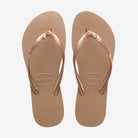 Chanclas Havaianas Slim Crystal Rose Gold mujer con tiras rose gold metalizadas y detalle de cristal sobre suela cómoda de goma ideales para verano, playa y piscina