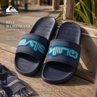 Chanclas de pala Quiksilver Rivi Wordmark Slide Blue en fotografía editorial propia de THE SURF TOWN sobre banco de madera surf con estilo coastal lifestyle y luz natural premium